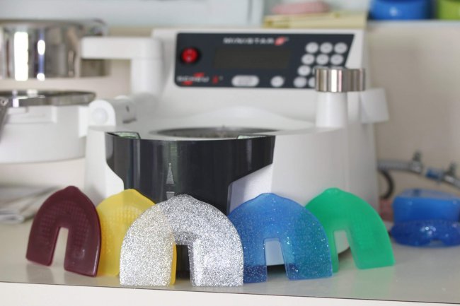 Mouthguard machine with different coloured mouthguard moulds.